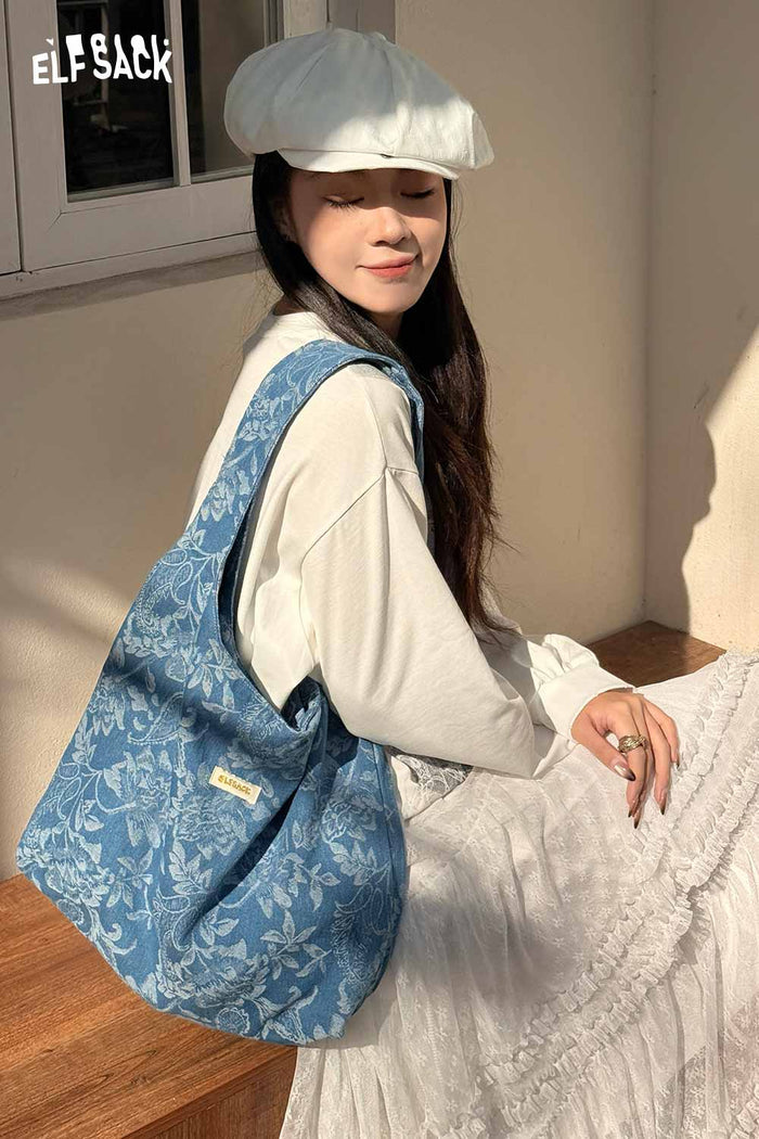 ELFSACK elegant denim blue bag featured on a model wearing a light outfit with a soft hat